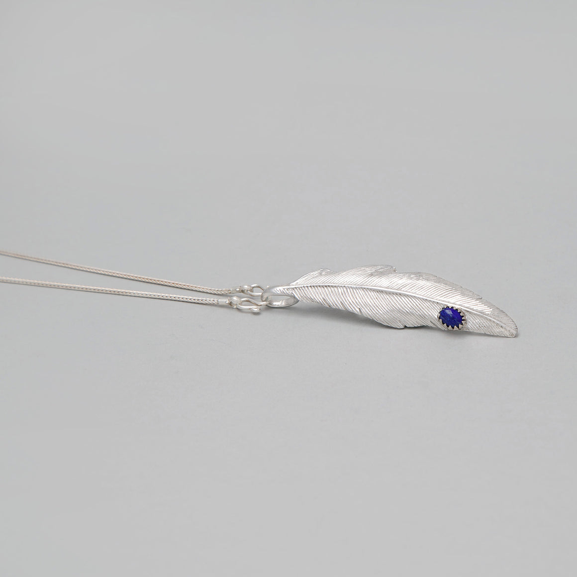 WHITE BRASS FEATHER PENDANT WITH LAPIS DROP
